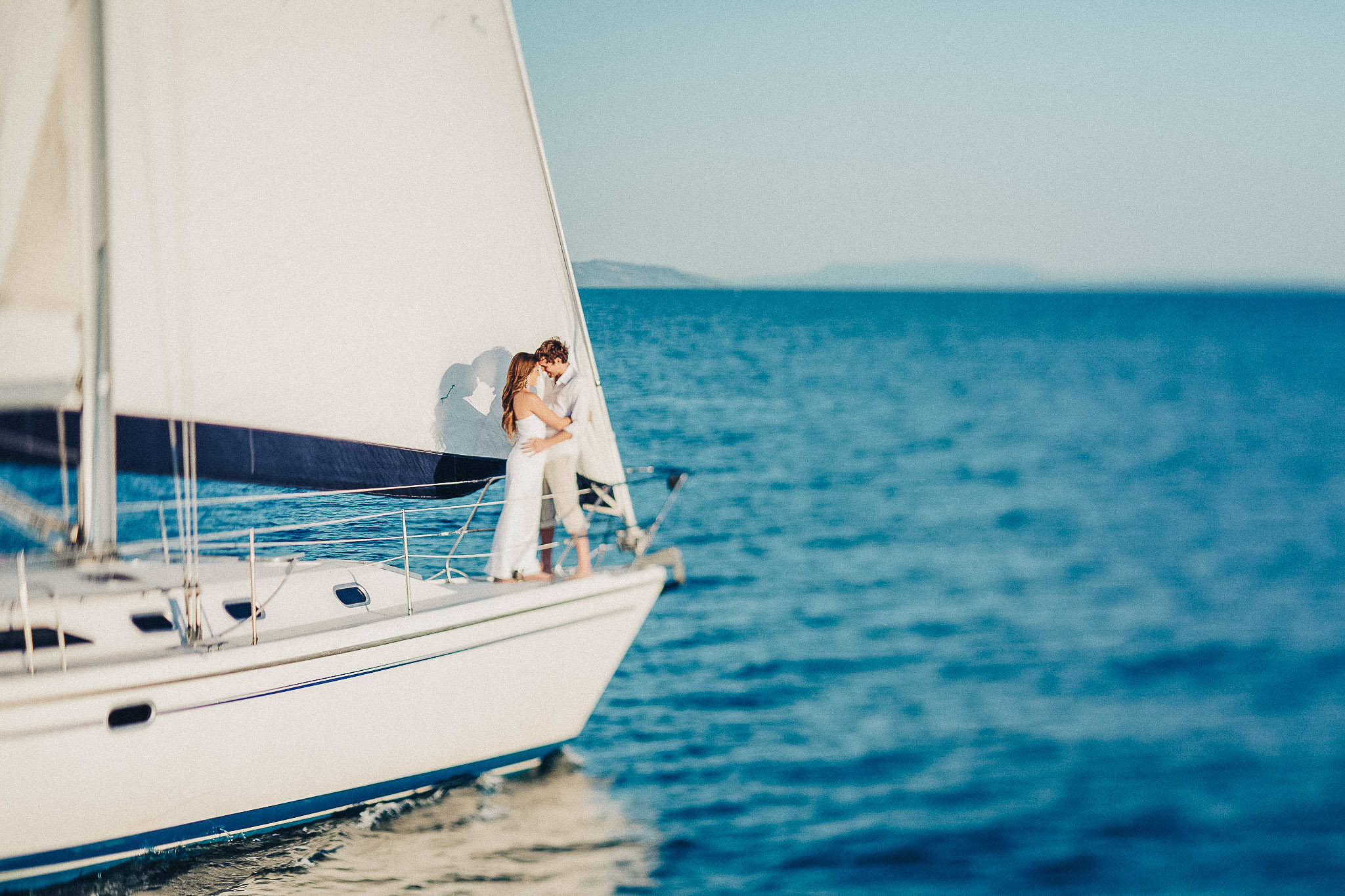 Wedding couple on a sailboat on blue water
